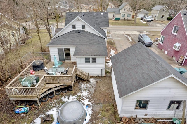 rear view of property featuring a shingled roof and a wooden deck