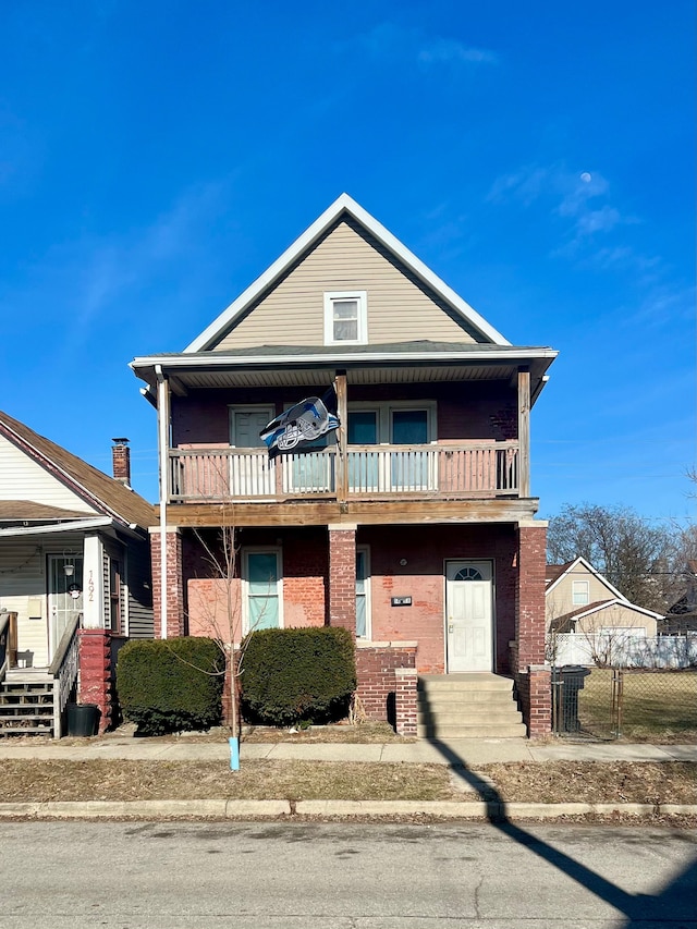 townhome / multi-family property featuring a balcony and brick siding