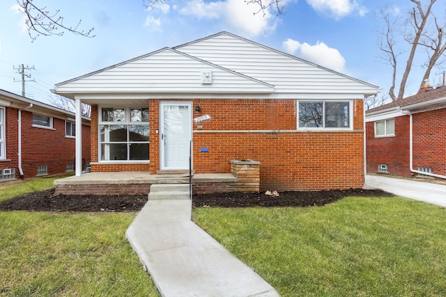 bungalow-style home with a front yard and brick siding