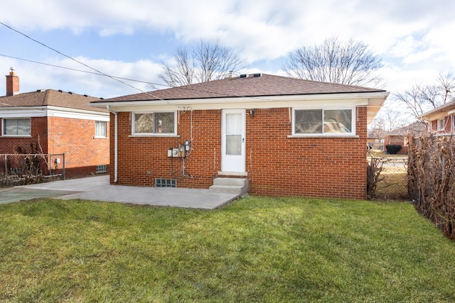 rear view of house featuring brick siding, a yard, a patio, entry steps, and fence