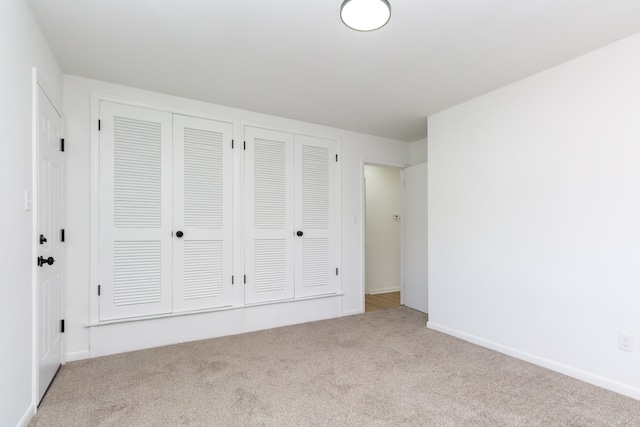 unfurnished bedroom with carpet flooring, baseboards, and two closets