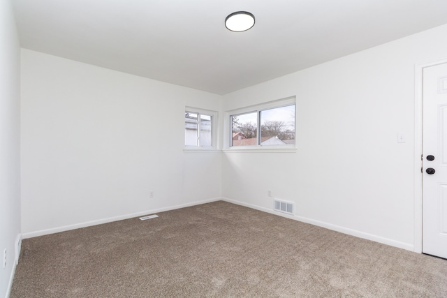 carpeted spare room with baseboards and visible vents