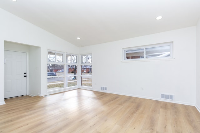 spare room featuring vaulted ceiling, recessed lighting, visible vents, and light wood-style floors