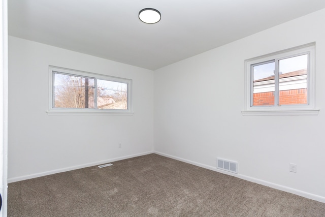 empty room featuring baseboards, visible vents, and carpet flooring