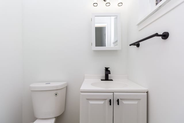 half bath featuring toilet and vanity