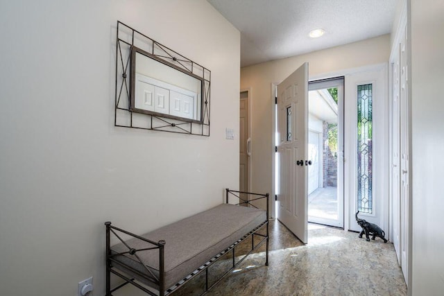 entryway with a textured ceiling and concrete floors