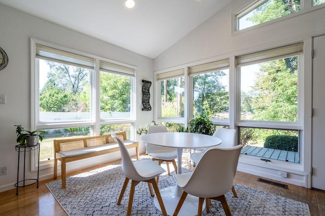 sunroom / solarium featuring a healthy amount of sunlight, visible vents, and vaulted ceiling