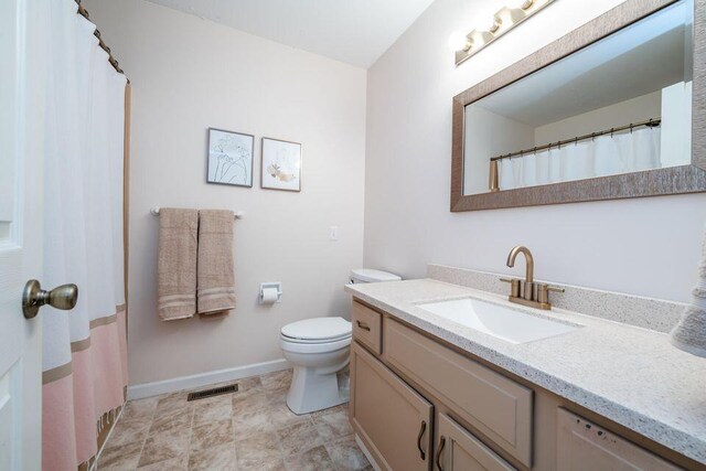 full bathroom featuring toilet, vanity, visible vents, and baseboards