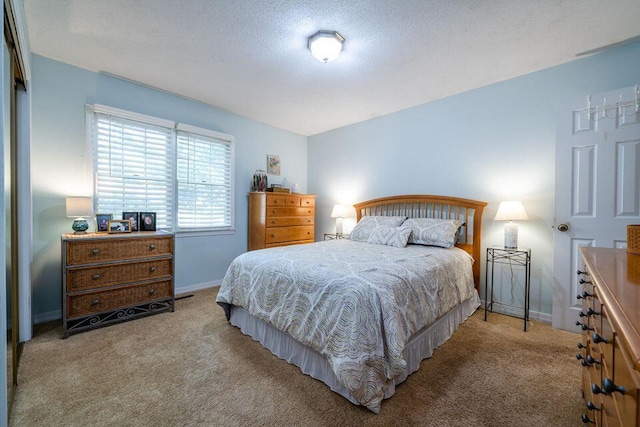 carpeted bedroom with baseboards and a textured ceiling