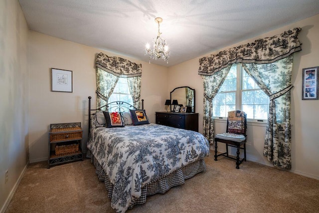 carpeted bedroom with a chandelier and baseboards