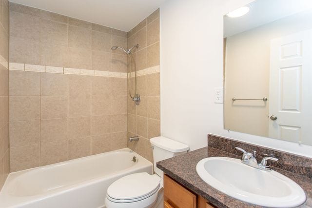 full bath with tub / shower combination, vanity, and toilet