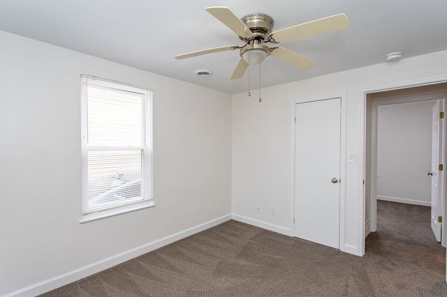 unfurnished room featuring ceiling fan, carpet flooring, visible vents, and baseboards