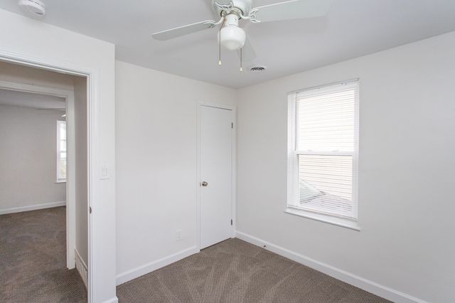 unfurnished bedroom featuring ceiling fan, carpet, visible vents, and baseboards