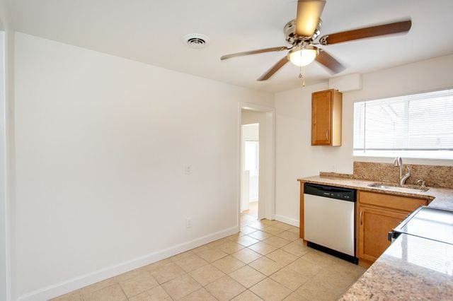 kitchen featuring visible vents, stainless steel dishwasher, light tile patterned flooring, a sink, and baseboards