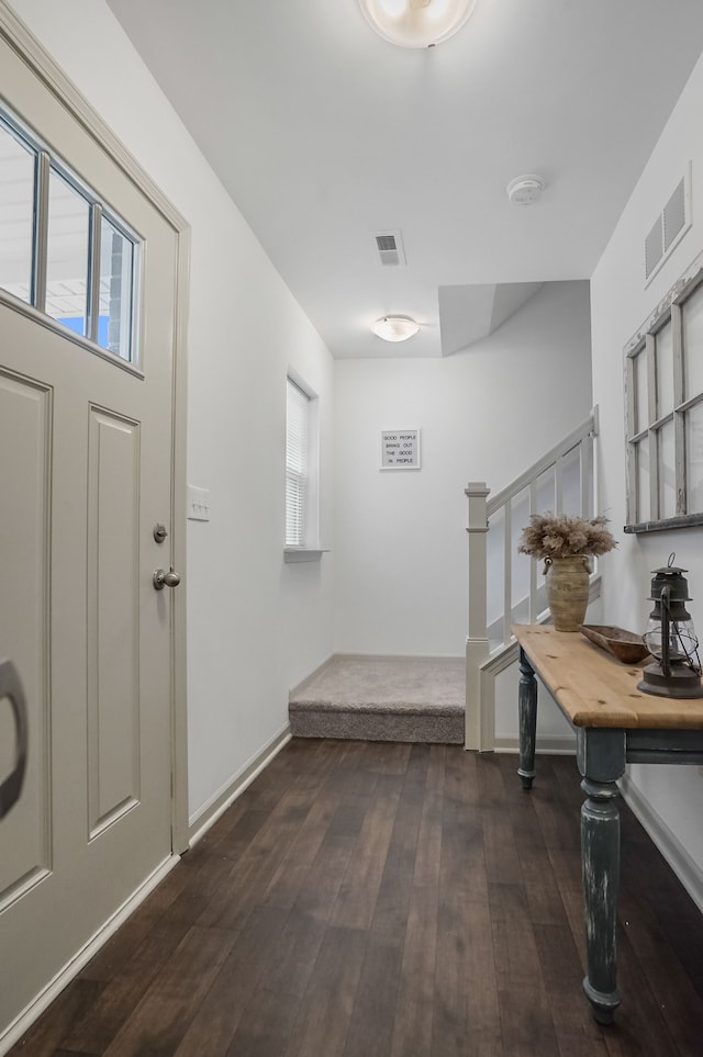 foyer entrance with plenty of natural light, dark wood finished floors, stairway, and baseboards