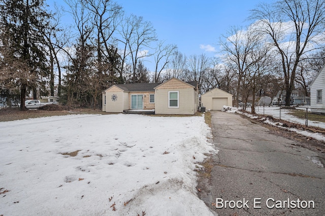 bungalow-style house with a garage, an outdoor structure, driveway, and fence