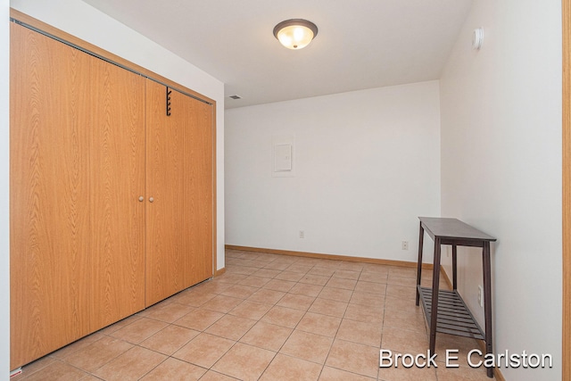 bedroom with light tile patterned floors, a closet, visible vents, and baseboards