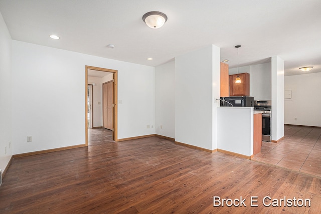 unfurnished living room featuring recessed lighting, baseboards, and wood finished floors