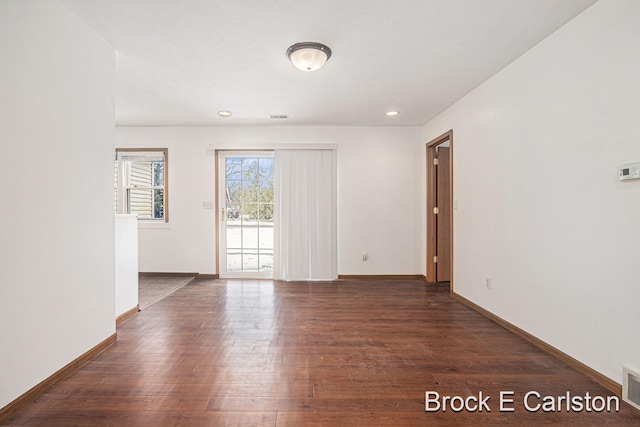 unfurnished room featuring recessed lighting, wood finished floors, visible vents, and baseboards