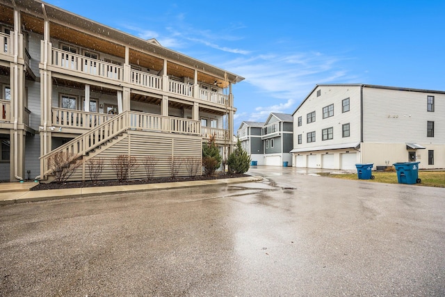 view of building exterior with stairs, driveway, and a residential view