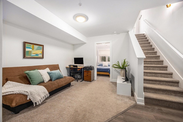 living area with baseboards, stairway, and wood finished floors