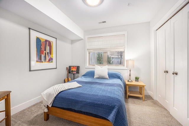 carpeted bedroom with baseboards, visible vents, and a closet