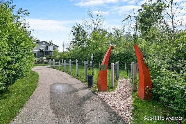 view of home's community featuring a gate, fence, and a lawn