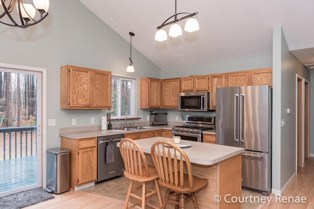 kitchen with stainless steel appliances, pendant lighting, light countertops, and a notable chandelier