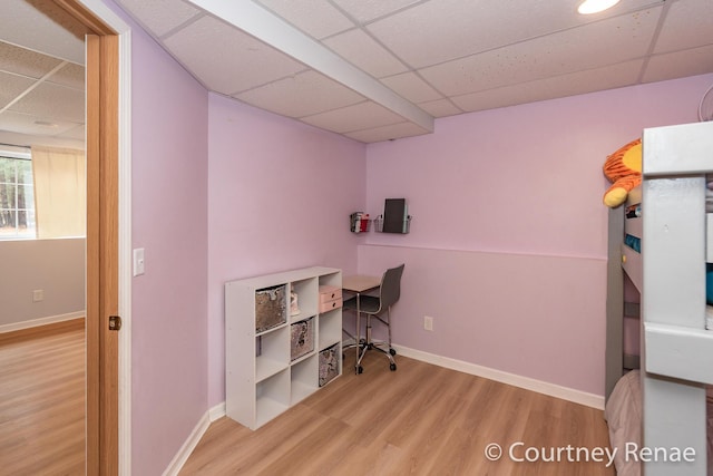 home office with a paneled ceiling, baseboards, and wood finished floors