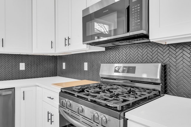 kitchen with appliances with stainless steel finishes, light countertops, white cabinetry, and tasteful backsplash