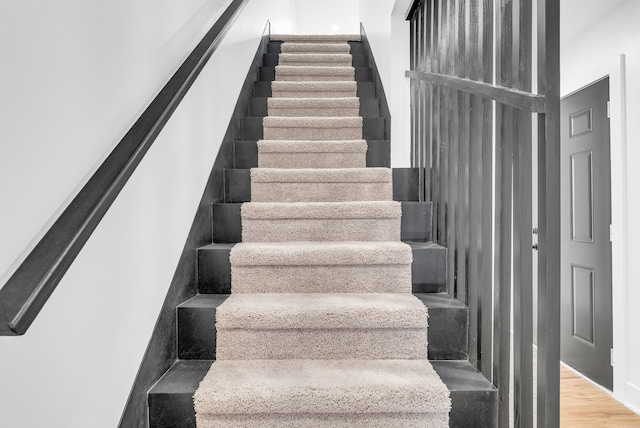 stairs featuring wood finished floors