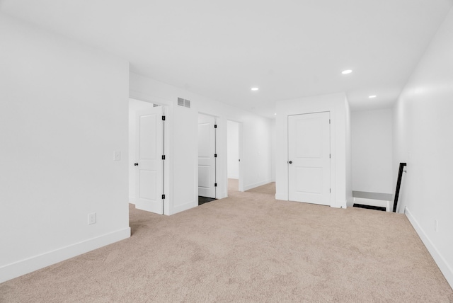 empty room featuring carpet, visible vents, baseboards, and recessed lighting