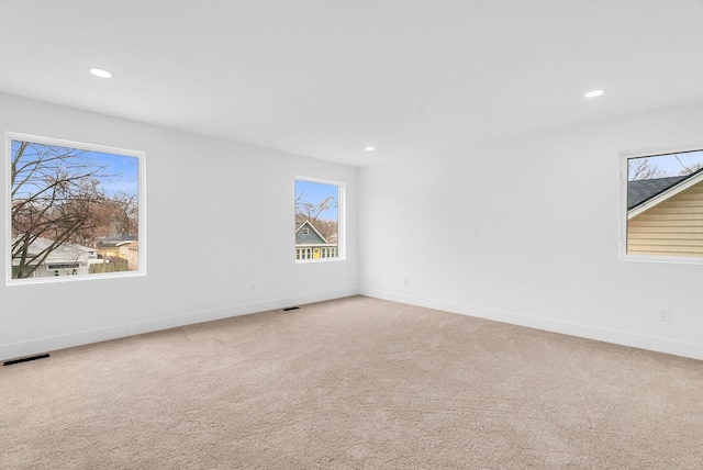 empty room featuring recessed lighting, light carpet, visible vents, and baseboards