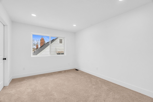 unfurnished room with baseboards, recessed lighting, and light colored carpet