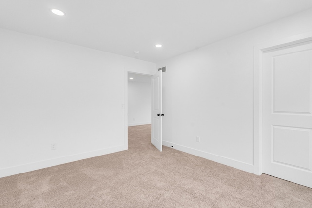 spare room featuring light carpet, baseboards, and recessed lighting