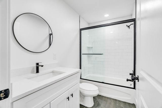 bathroom with shower / bath combination with glass door, vanity, and toilet