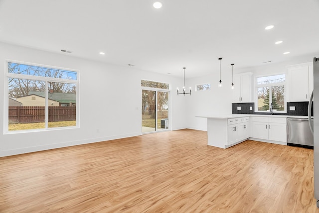 kitchen with a peninsula, tasteful backsplash, open floor plan, and dishwasher