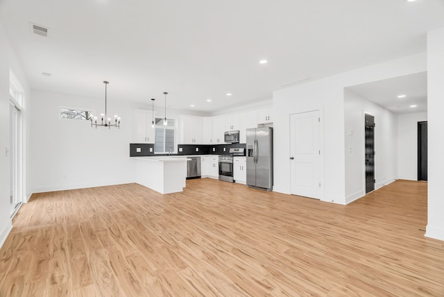 kitchen featuring stainless steel appliances, tasteful backsplash, visible vents, light wood-style floors, and open floor plan