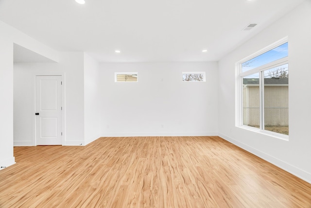 unfurnished room with light wood-type flooring, visible vents, baseboards, and recessed lighting