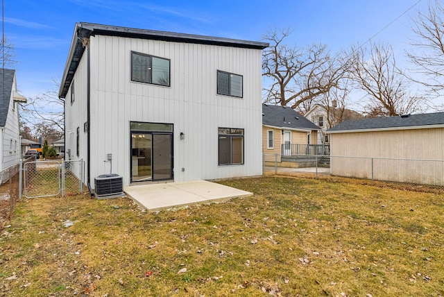 back of house featuring a lawn, a patio, a fenced backyard, a gate, and central AC