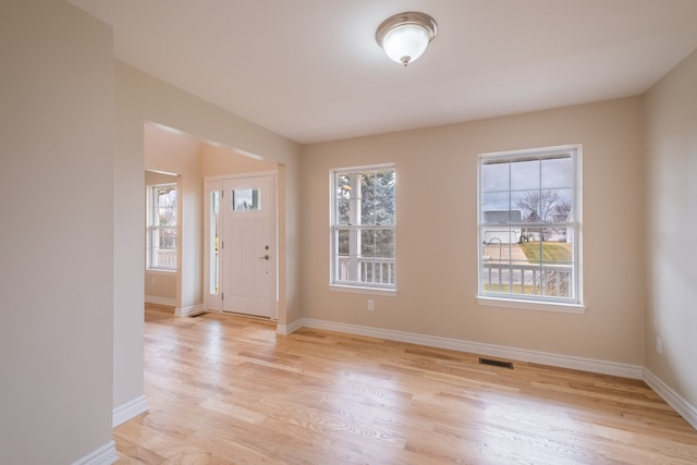 foyer featuring light wood-type flooring, visible vents, and baseboards