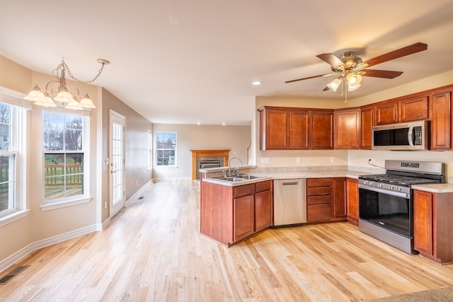 kitchen with a peninsula, a sink, visible vents, light countertops, and appliances with stainless steel finishes