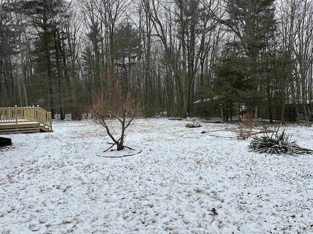 yard layered in snow featuring a deck