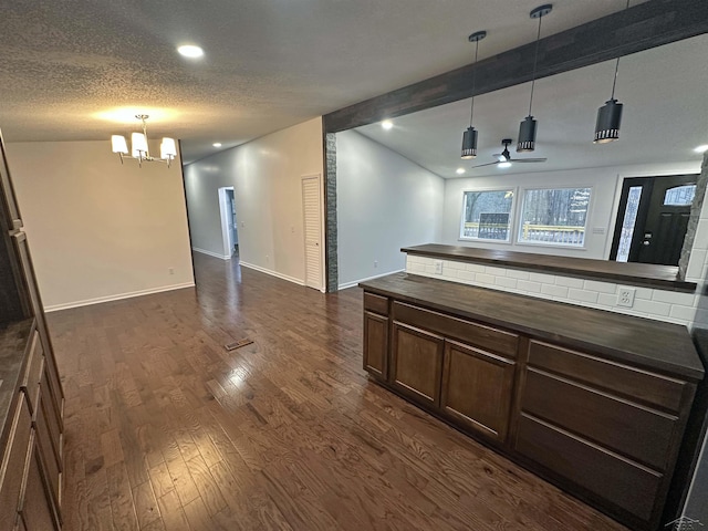 interior space featuring dark wood-style flooring, lofted ceiling with beams, open floor plan, a textured ceiling, and baseboards