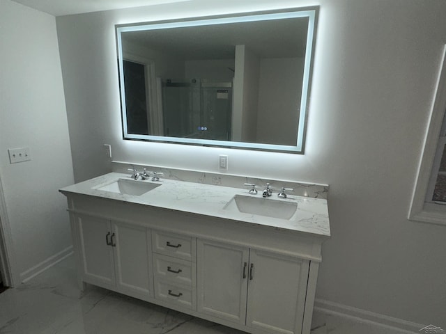 bathroom featuring marble finish floor, a sink, baseboards, and double vanity