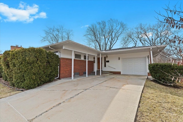 ranch-style house with brick siding, an attached garage, and driveway