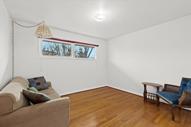 living area with baseboards and hardwood / wood-style floors