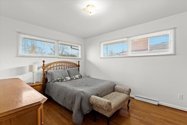 bedroom featuring wood finished floors, baseboards, and a baseboard radiator