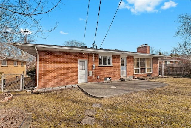 rear view of property with a gate, fence, a yard, entry steps, and brick siding