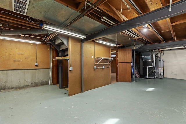 unfinished basement featuring heating unit, visible vents, and water heater